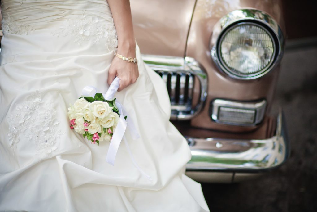 Wedding flowers bouquet and a vintage tan coloured car